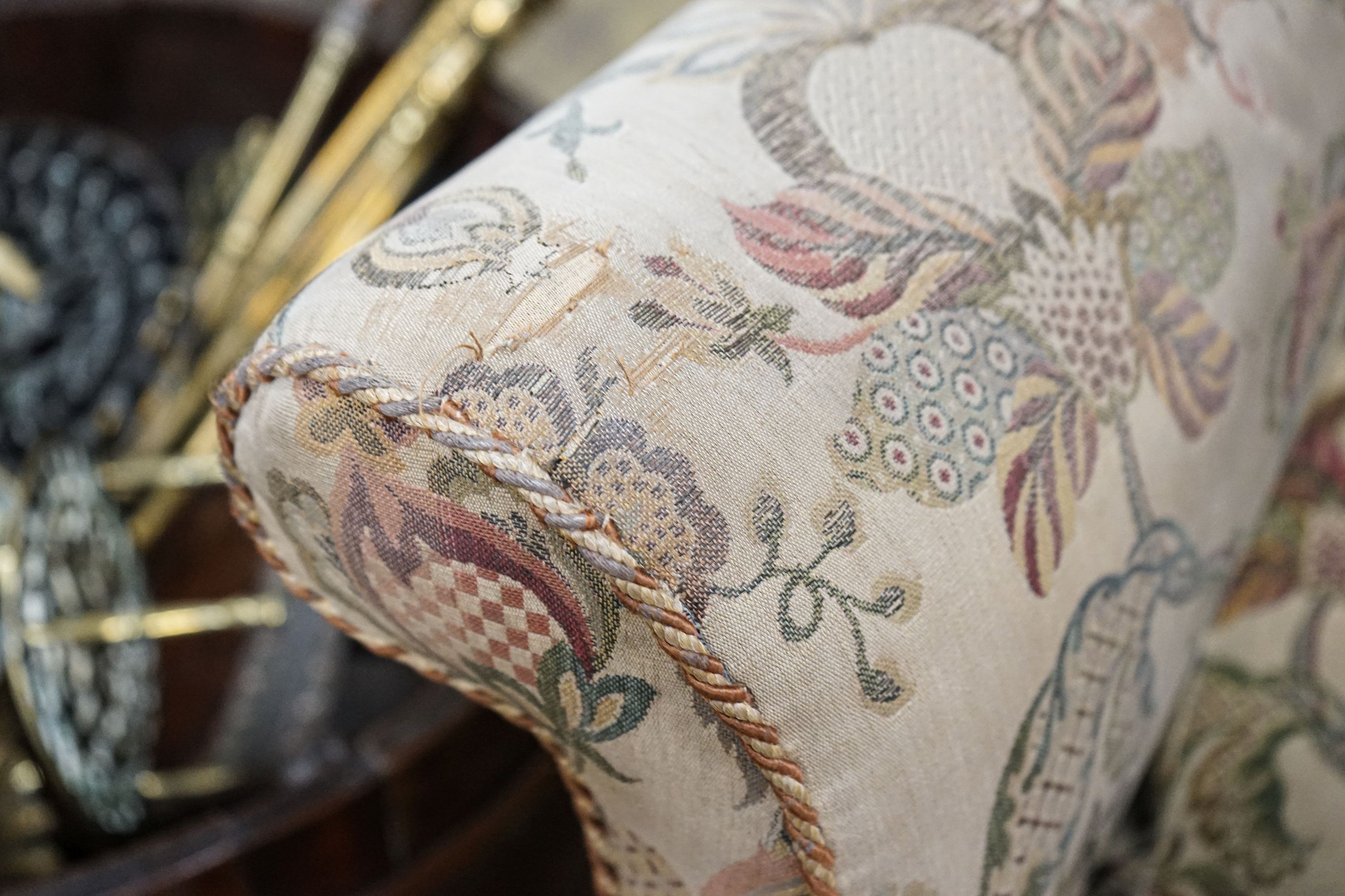 A William & Mary style walnut wing armchair, with flowering scroll upholstery and turned underframe with serpentine stretcher, width 86cm, depth 66cm, height 130cm